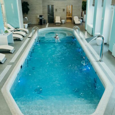 Bright indoor spa pool with lounge chairs and calm atmosphere, ideal for relaxation.